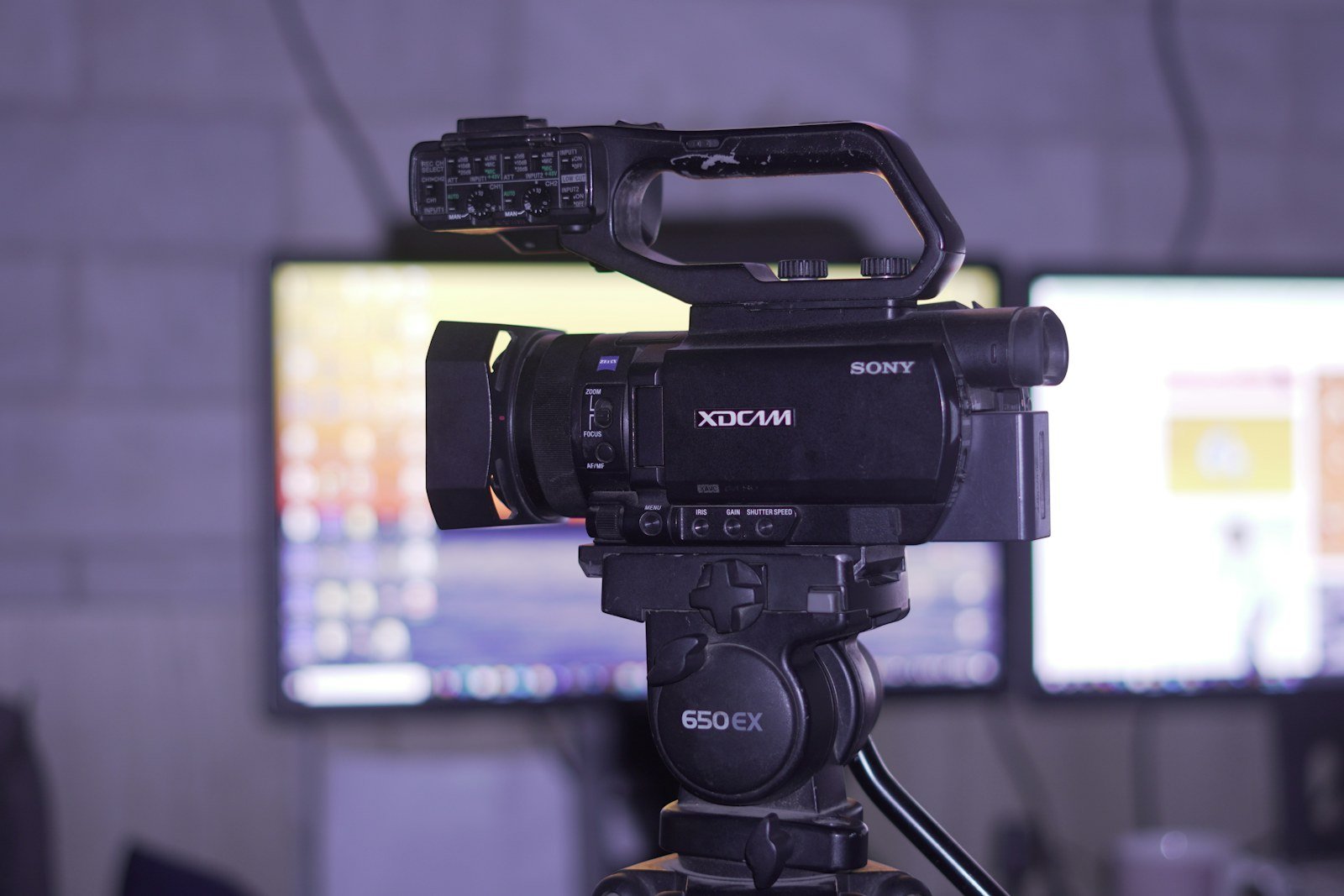 كاميرا فيديو احترافية أمام شاشات بإضاءة بنفسجية لشرح Monitor LUT أثناء التصوير