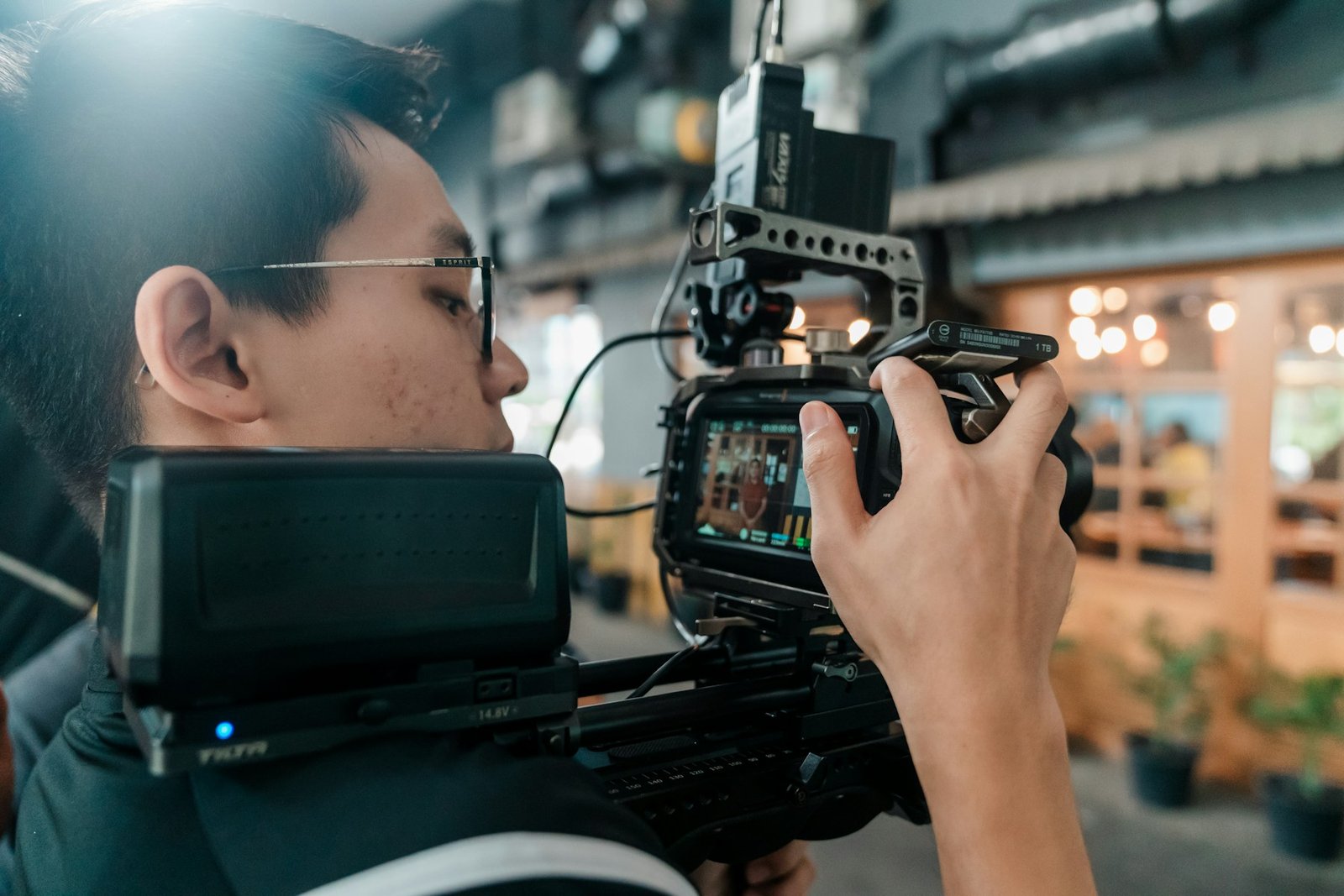 مشغل كاميرا سينمائية يضبط إعدادات التسجيل قبل تصوير مشهد غني بالتفاصيل الدقيقة